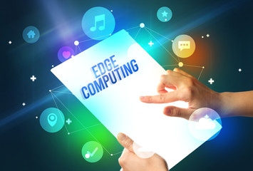 Holding futuristic tablet with EDGE COMPUTING inscription, new technology concept