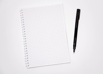 Squared notebook with black pen on a white background. Record ideas, notes, plans, tasks.  Notebook top and side view. Flatlay. Copy Space