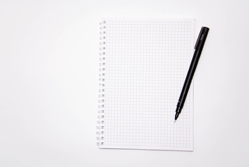 Squared notebook with black pen on a white background. Record ideas, notes, plans, tasks.  Notebook top and side view. Flatlay. Copy Space