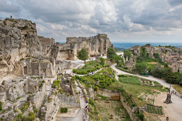 Fototapeta premium Aerial view to medieval fortress Les Baux de Provence.Tourists visit the castle at Baux-de-Provence.Les Baux relying on a reputation as one of the most picturesque villages in France, Bouches-du-Rhône