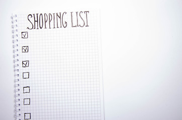 Shopping list. Squared notebook with black pen on a white background. Record ideas, notes, plans, tasks. The list includes bread, milk, bananas.  Copy Spase