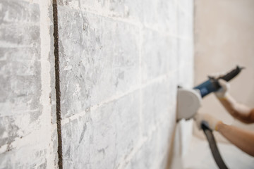 Builder man cutting electrical chase in concrete wall with groove machine diamond crown