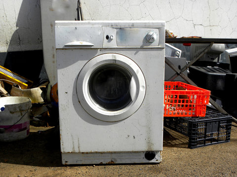 Large Dump Of Old And Unusable Ferrous Material And A Large Broken Washing Machine.    Heap Of Old Scrap Metal Mainly Consist Of Household Appliance In A Scrap Yard.           