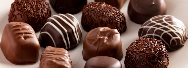 Assorted Chocolate Truffles on a Rustic Wooden Table in a Dark Environment