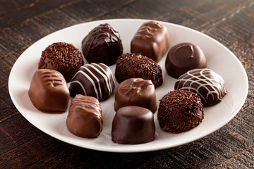 Assorted Chocolate Truffles on a Rustic Wooden Table in a Dark Environment