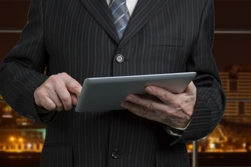 Close up caucasian male hands tapping tablet. Businessman in suit with electronic device.