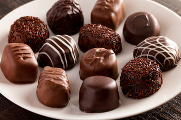 Assorted Chocolate Truffles on a Rustic Wooden Table in a Dark Environment