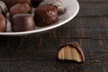 Assorted Chocolate Truffles on a Rustic Wooden Table in a Dark Environment