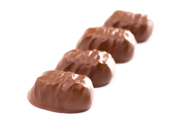 Five Milk Chocolate Truffles in a Row on a White Background