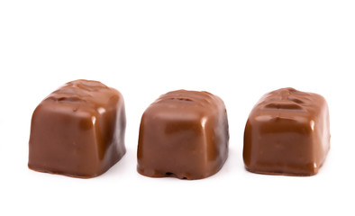 Three Milk Chocolate Truffles in a Row on a White Background