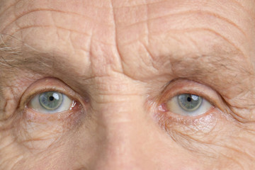 Widely opened blue grandpa eyes. Excited old man, macro view. Extreme close up.