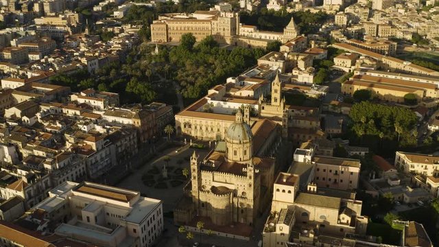 Cinematic flight early sunny morning over the Cattadrale Santa Vergine Maria Assunta, Palazzo dei Normanni, Cappella Palatina, in the historic part of Palermo. Sicily, Italy. May 2019. Aerial shot