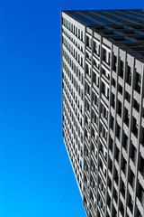 many Windows of a skyscraper. brick walls with Windows. Texture of a skyscraper against a blue sky