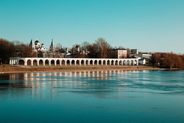 Fototapeta na wymiar arcade on the embankment of the river and the white Orthodox church behind it