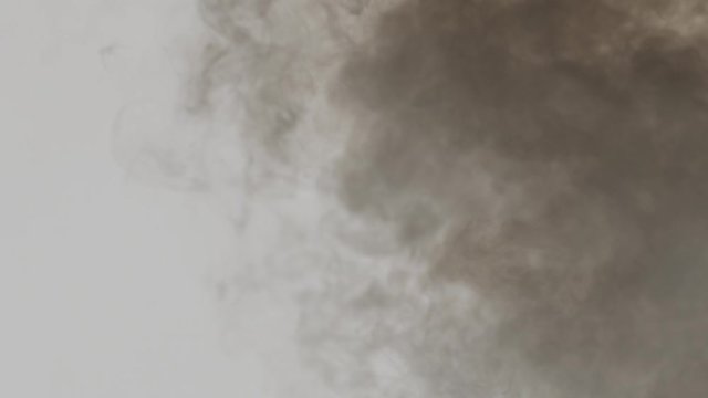 Closeup of emission to the air of dark polluting fumes as dioxin. Exhaust gases. Burning tires and plastics.  