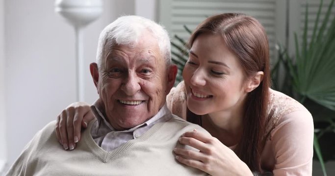 Loving smiling young granddaughter hug old grandfather, family portrait