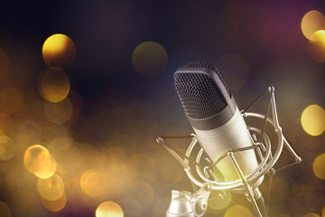 Gray studio condenser microphone on blur festive holiday lights