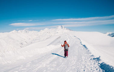 Skier makes photo on top of snowy mountain at nice sun day. Caucasus Mountains in winter, Georgia, region Gudauri.