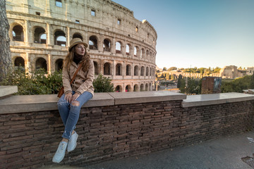 Fototapeta na wymiar Roman Holiday. Portrait of happy young woman in the front of Colosseum in Rome, Italy