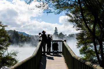 women tourists looking at steam of hot springs in rotorua