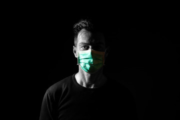 Portrait of  sick caucasian man with medical mask. Coronavirus Covid-19 concept. Black background.  Black and white