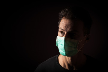 Portrait of  sick caucasian man with medical mask. Coronavirus Covid-19 concept. Black background 