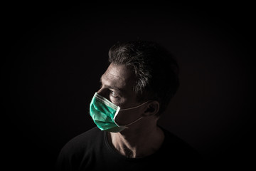 Portrait of  sick caucasian man with medical mask. Coronavirus Covid-19 concept. Black background 