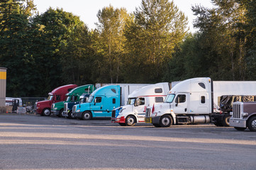 Fototapeta na wymiar Truck stop. A row of trucks during a stopover, travel breaks.
