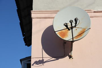Round television antenna on the wall of the house. Satellite antenn