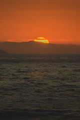 Puesta de sol en medio del mar  el sol ocultándose 
