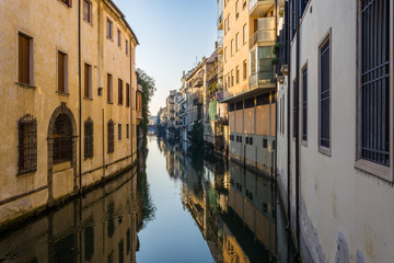 Fototapeta na wymiar Reflections of the houses on the canal that crosses Padova