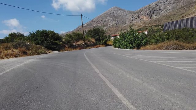 Rear View Camera. Driving a car on a mountain road on a summer day. Crete island, Greece. Car rental and travel concept.