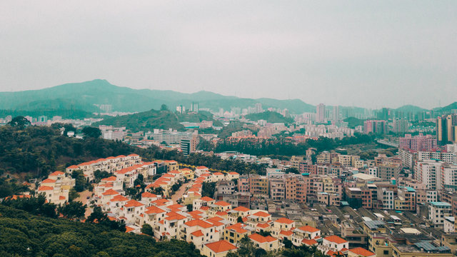 City suburbs in China, covered in smog between the mountains.