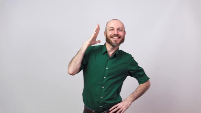 Funny dance of a man wearing shirt. Cheerful bearded bald man dancing and having fun on white background.