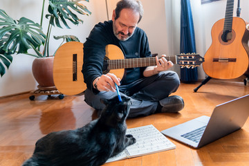 Seniors man are playing a guitar at home. Retired man learning playing a guitar.