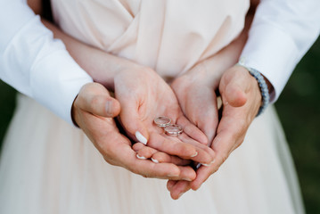 the bride and groom held hands with wedding rings