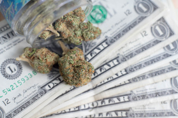 marijuana spilling out of a jar onto dollar bills investing concept