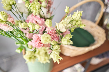 Education in the school of floristry. Master class on making bouquets. Summer bouquet in a wicker basket.. Learning flower arranging, making beautiful bouquets with your own hands. Flowers delivery