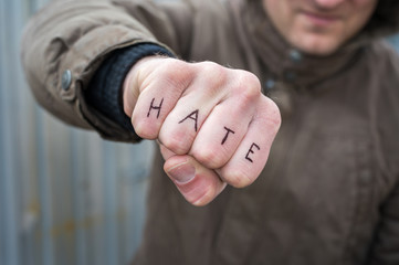Faust mit dem Wort Hass in englischer Sprache als Symbol für Hass und Brutalität