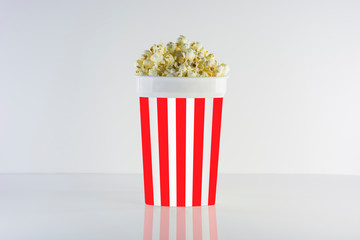 Popcorn box isolated on clean natural background. Good for watching cinema and movies. Delicious but unhealty nutrition.