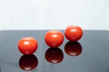 Trzy pomidory na czarno białym tle. pomidory koktajlowe