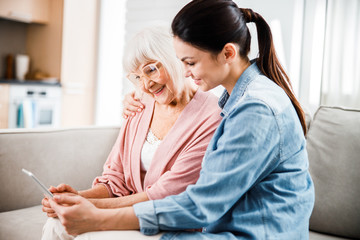 Grandmother and granddaughter using modern digital tablet