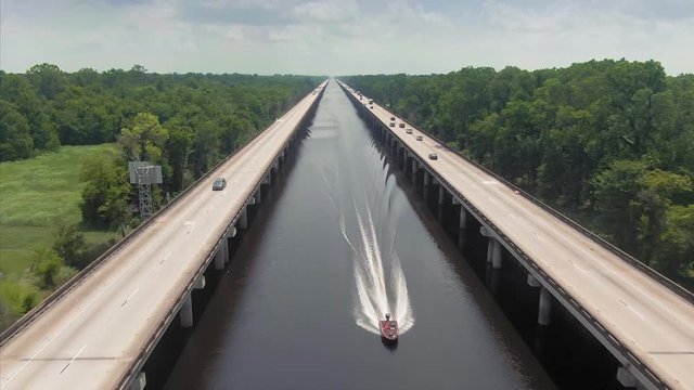 Swamp river, speedboat and Interstate 10 Freeway cutting through it. New Orleans, Louisiana, USA