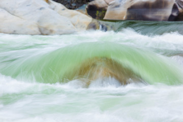 Fototapeta na wymiar soft green river water over rocks