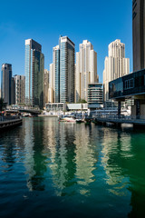Fototapeta na wymiar blue, sky, Sunny, day, space, distance, panorama, city, street, houses, high-rises, skyscrapers, buildings, structures, concrete, glass, channel, emerald, water, reflections, pier, pier, style, archit