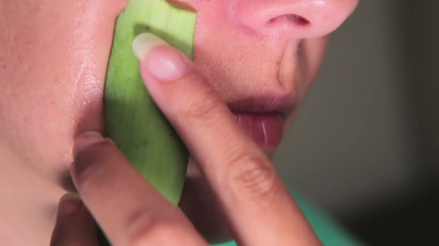 Young woman puts aloe vera gel on her face. Using a fresh aloe vera gel for the face. Aloe Vera gel care
