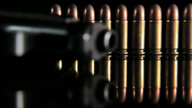 Handgun and bullets in a row. Group of bullets and handgun on the table slider shoot