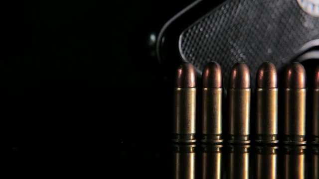 Handgun and bullets in a row. Group of bullets and handgun on the table slider shoot