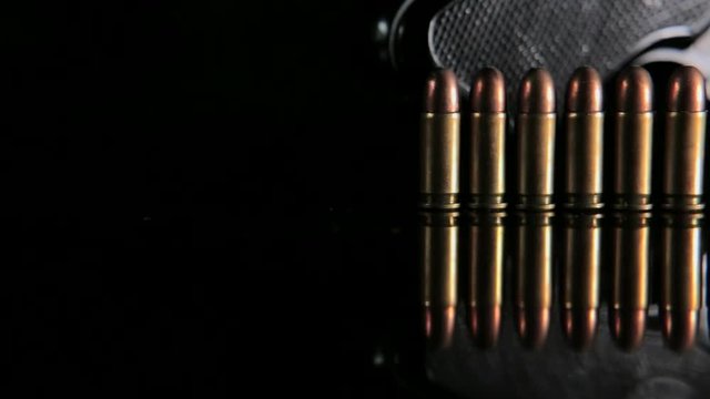 Handgun and bullets in a row. Group of bullets and handgun on the table slider shoot