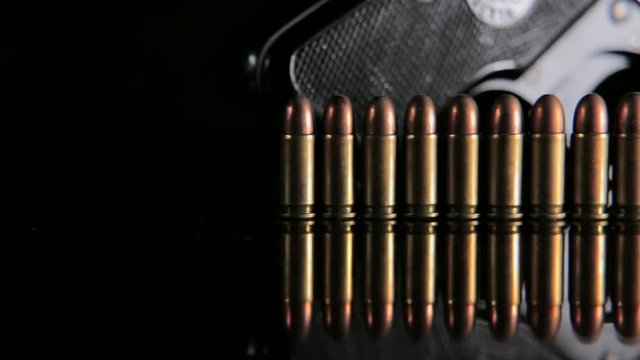 Handgun and bullets in a row. Group of bullets and handgun on the table slider shoot